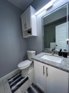 ein Badezimmer mit einem WC, einem Waschbecken und einem Spiegel in der Unterkunft San Juan modern Apartments in San Juan