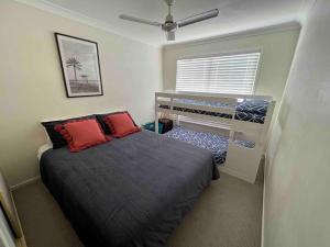 1 dormitorio pequeño con 1 cama y ventilador en Sandstone Point 4-bedroom Home, en Sandstone Point