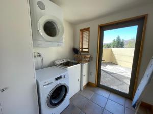 a laundry room with a washer and dryer at Towan House at Carrick Winery in Cromwell