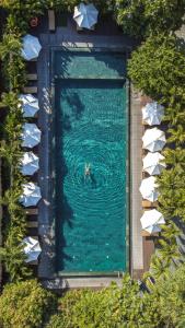 a person in the water in a swimming pool at Mulberry Collection Silk Village in Hoi An