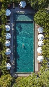 eine Person im Wasser in einem Pool in der Unterkunft Mulberry Collection Silk Village in Hoi An