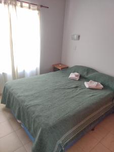 a bedroom with a green bed with two towels on it at Amor y Paz in Carpintería