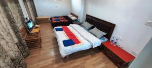ein Schlafzimmer mit 2 Betten und einem TV in der Unterkunft Lynx near Leh airport in Leh