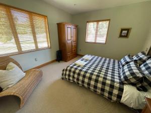 a bedroom with a bed and a couch and windows at Towan House at Carrick Winery in Cromwell