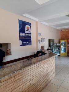 a bar in a restaurant with a person sitting at a counter at Hotel Beira Rio in Aquidauana