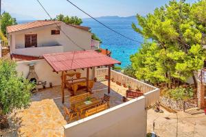 a house with a balcony with a view of the ocean at Apartments Secret Beach in Mimice