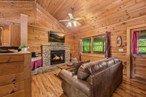 a living room with a couch and a fireplace at Romantic log cabin with hot tub in Pigeon Forge
