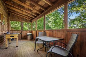 a room with a table and chairs in a cabin at Romantic log cabin with hot tub in Pigeon Forge