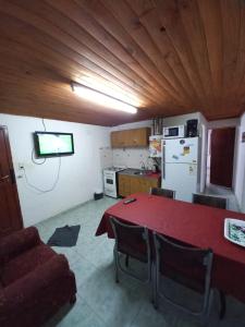 a kitchen with a red table with chairs and a television at Los girasoles in Esquel