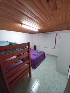 1 dormitorio con cama y techo de madera en Los girasoles en Esquel