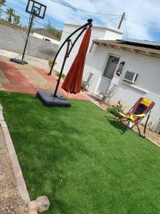 a lawn with an umbrella and a chair on it at ULTRA COZY CASITA BY DTWN PHX in Phoenix