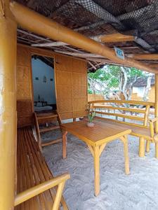 a room with a table and benches in a building at Casa Astillero - Calatagan Batangas Private Resort in Calatagan