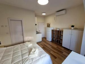 a bedroom with a white bed and a kitchen at Jaffa 17 - Lihi brand new studio in Jerusalem