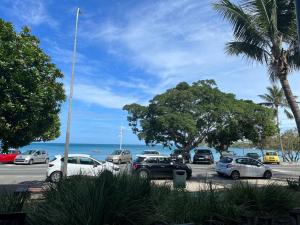 a parking lot with cars parked next to the ocean at Studio tropical baie des citrons in Noumea