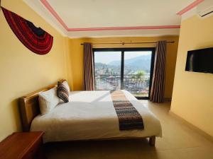 een slaapkamer met een bed en een groot raam bij Sapa Paramount Hotel in Sa Pa