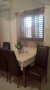 a dining room table with two chairs and a window at Nikolina Rooms in Dubrovnik