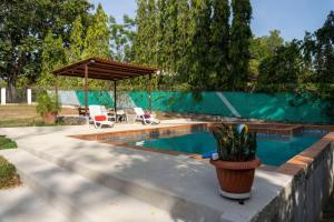 uma piscina com um pavilhão e um pátio em Villa Thais em Nueva Gorgona