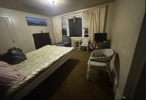 - une chambre avec un lit, une chaise et une fenêtre dans l'établissement JC Denman, à Corona