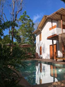 a villa with a swimming pool and a house at Villa Sagui Trancoso in Trancoso