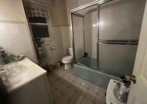 a bathroom with a tub and a toilet and a sink at JC Denman in Corona