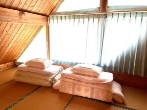 two beds in a room with a window at Kurokawa Marigold in Minamioguni