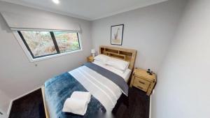 a small bedroom with a bed and a window at 5 Bedroom, Solar on Snowmass Ohakune, Yellow Door in Ohakune
