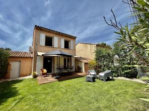 a backyard with a house with a lawn at Maison Calme 6 Pers. au Golf Pont Royal - Piscine, Terrasse, Parking, Clim, Fibre - 13370 Mallemort - FR-1-658-24 in Mallemort