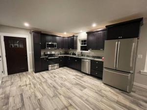 a large kitchen with wooden floors and stainless steel appliances at Riverside Getaway with HotTub 3br 2 bth in Brewer