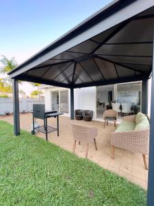 a black pavilion with chairs and a table and a piano at The OC Home: Centrally Located, Home Away Home in Nightcliff
