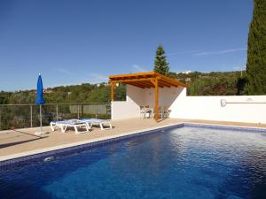una piscina con una mesa y un pabellón en Secluded villa with a private swimming pool, en Santa Bárbara de Nexe