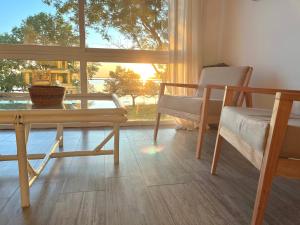 sala de estar con mesa, sillas y ventana en Atardeceres Chascomús en Chascomús