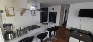 波哥大的住宿－Wohnung Queens Deluxe，厨房配有黑色凳子和白色台面