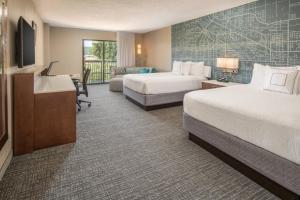 a hotel room with two beds and a television at Courtyard Seattle Sea-Tac Area in Tukwila