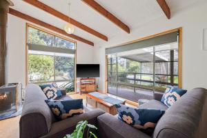 a living room with two couches and a fireplace at Plover Haven in Cowes