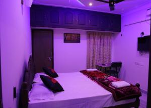 a purple room with a bed and a table at Malpans Mansion Villa in Nedumbassery