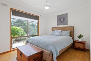 a bedroom with a bed and a large window at Plover Haven in Cowes