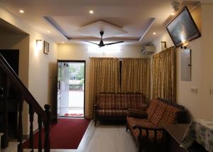 a living room with a couch and a tv on the ceiling at Malpans Mansion Villa in Nedumbassery