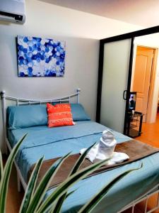 - une chambre avec un lit doté de draps bleus et d'oreillers rouges dans l'établissement Cozy condo for rent, à Davao