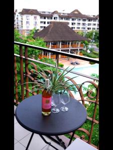 une table avec deux verres et une plante sur un balcon dans l'établissement Cozy condo for rent, à Davao