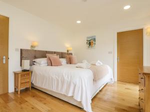 a bedroom with a large white bed and a wooden floor at Elm in Truro