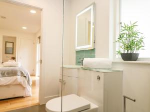y baño con aseo y lavabo con espejo. en Elm, en Truro 42 fotos más