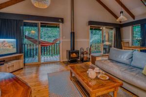 a living room with a couch and a fireplace at Narrows Escape Rainforest Retreat in Montville