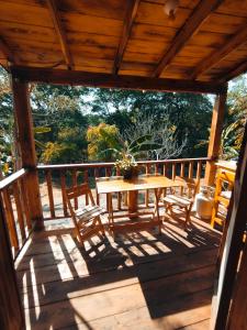 una terraza de madera con mesa y sillas. en La cabaña de Aurora en Comala