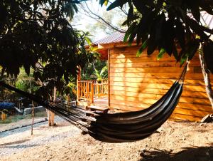 una hamaca frente a una cabaña de madera en La cabaña de Aurora en Comala