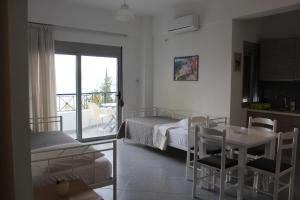 1 dormitorio con cama, mesa y balcón en Margaritas Apartments en Sarandë