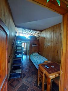 1 dormitorio con 1 cama y 1 mesa en una habitación en Cabañas Armandiños, en Pichidangui