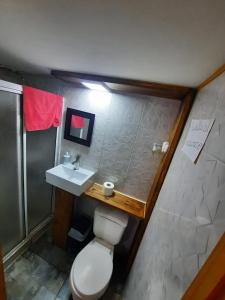 a bathroom with a toilet and a sink at Cabañas Armandiños in Pichidangui