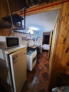 a small kitchen with a stove and a microwave at Cabañas Armandiños in Pichidangui