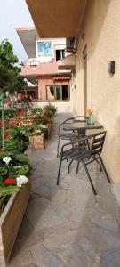 a patio with a table and chairs and flowers at Casa.Costiera in Palaiochóra