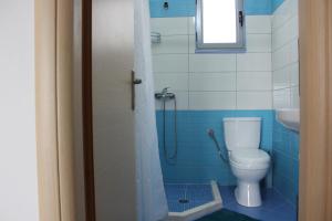 Baño azul con aseo y lavamanos en Margaritas Apartments en Sarandë